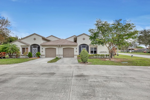 mediterranean / spanish home featuring a garage and a front yard