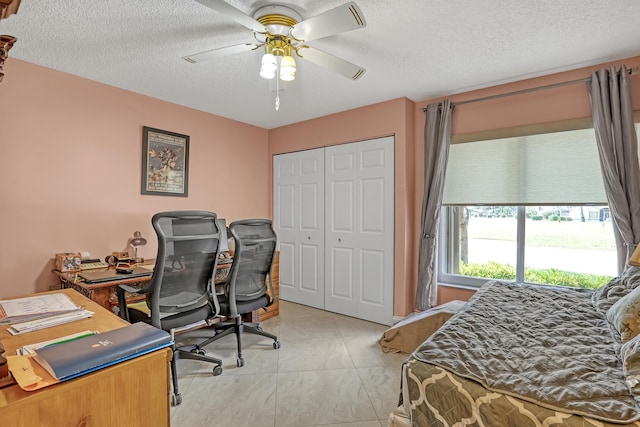 bedroom with ceiling fan, a closet, and a textured ceiling