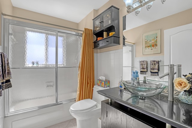 full bathroom featuring enclosed tub / shower combo, tile walls, vanity, tile patterned floors, and toilet