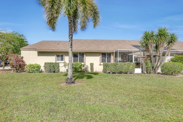 view of front of home featuring a sunroom and a front lawn