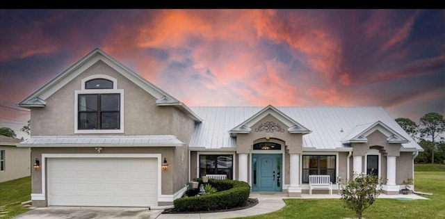 view of front of house with a garage and a lawn