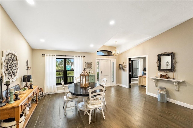 dining space with dark wood-type flooring, an inviting chandelier, and lofted ceiling