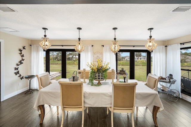 dining space with french doors, a textured ceiling, and dark hardwood / wood-style floors