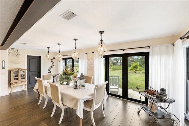 dining room with a textured ceiling, french doors, a chandelier, and dark hardwood / wood-style flooring