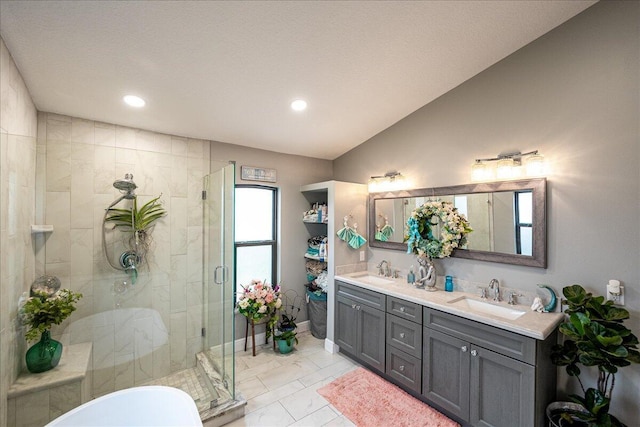 bathroom featuring vanity, a shower with shower door, and lofted ceiling