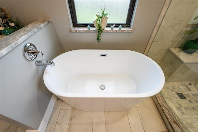 bathroom with a relaxing tiled tub