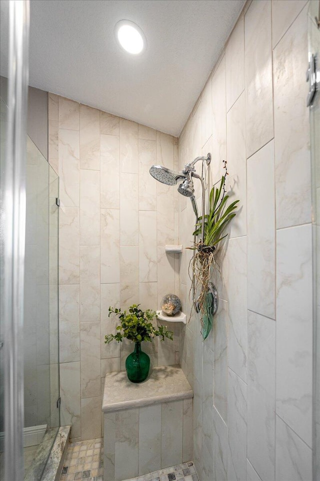 bathroom with a tile shower and tile walls