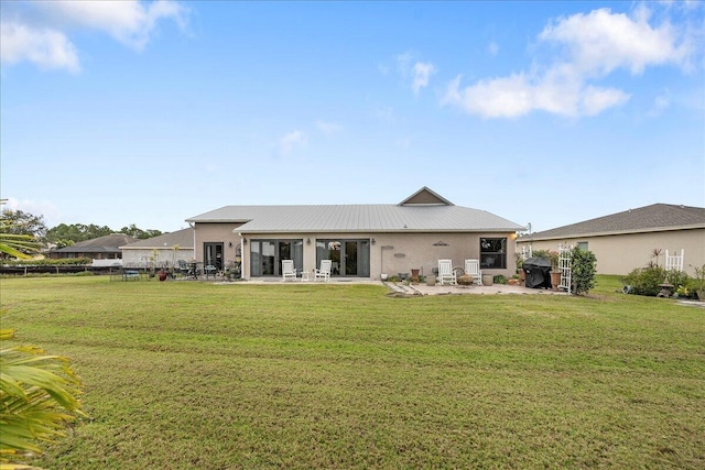 rear view of house featuring a yard and a patio area