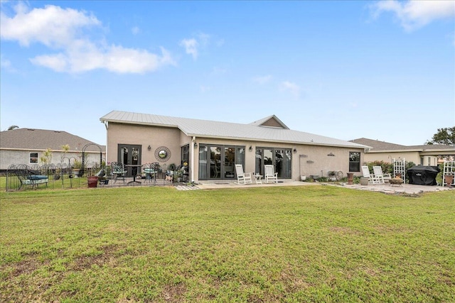 back of property featuring french doors, a patio, and a lawn