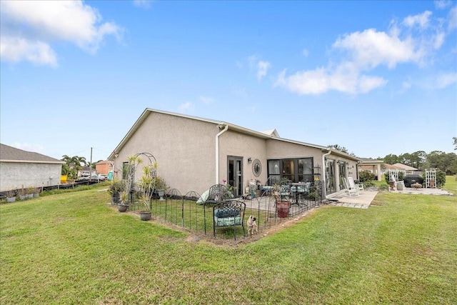 back of house featuring a patio and a yard