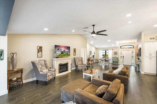 living room featuring ceiling fan, vaulted ceiling, dark hardwood / wood-style flooring, and a textured ceiling