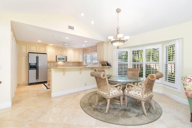 dining area featuring lofted ceiling and ceiling fan with notable chandelier