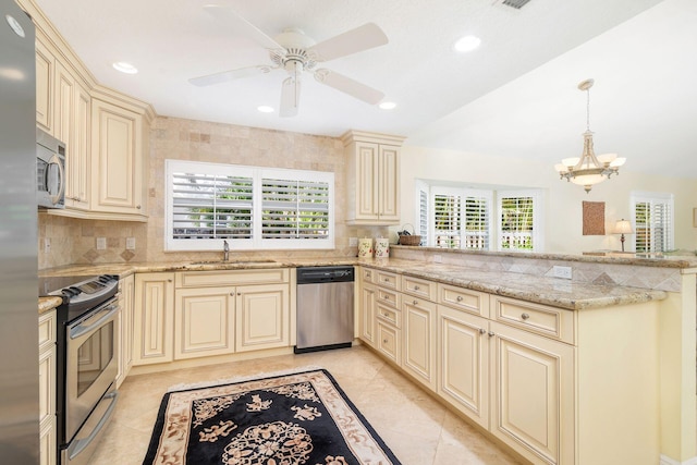 kitchen with appliances with stainless steel finishes, sink, cream cabinets, and kitchen peninsula