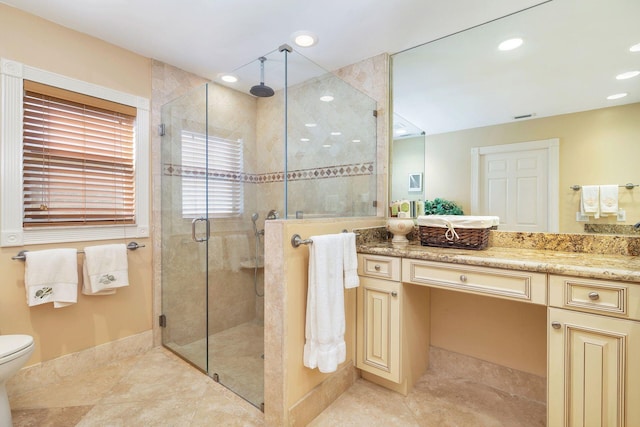 bathroom with vanity, a shower with door, and toilet