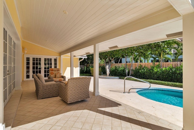 view of pool with french doors, an outdoor living space, and a patio