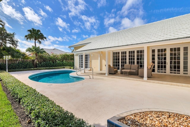 view of swimming pool with a patio and french doors