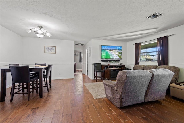 living room featuring an inviting chandelier and a textured ceiling