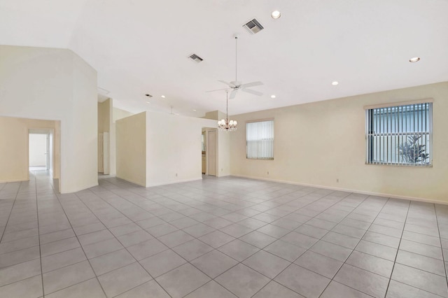 tiled spare room featuring vaulted ceiling and ceiling fan with notable chandelier