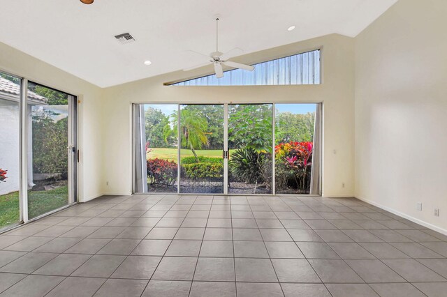 tiled spare room with ceiling fan, plenty of natural light, and high vaulted ceiling