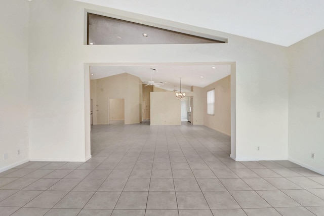 tiled spare room with lofted ceiling and a chandelier