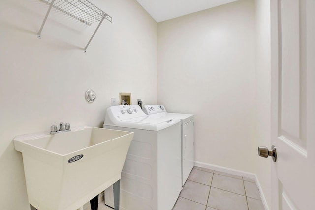 laundry area featuring separate washer and dryer, sink, and light tile patterned floors