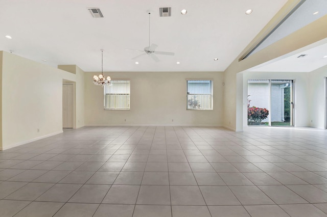 tiled spare room featuring lofted ceiling, a healthy amount of sunlight, and ceiling fan with notable chandelier