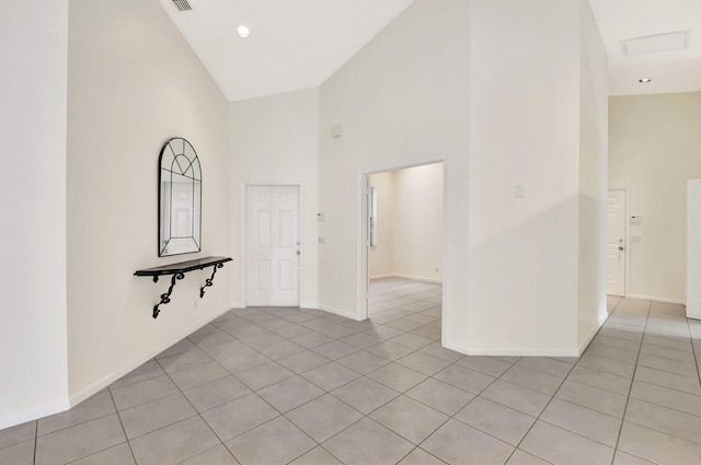 tiled spare room with high vaulted ceiling