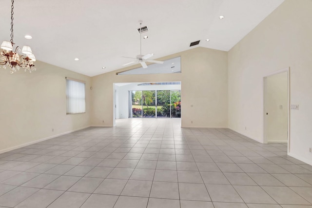 empty room with light tile patterned floors, ceiling fan with notable chandelier, and high vaulted ceiling