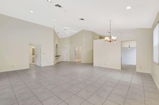 tiled empty room featuring high vaulted ceiling and ceiling fan with notable chandelier