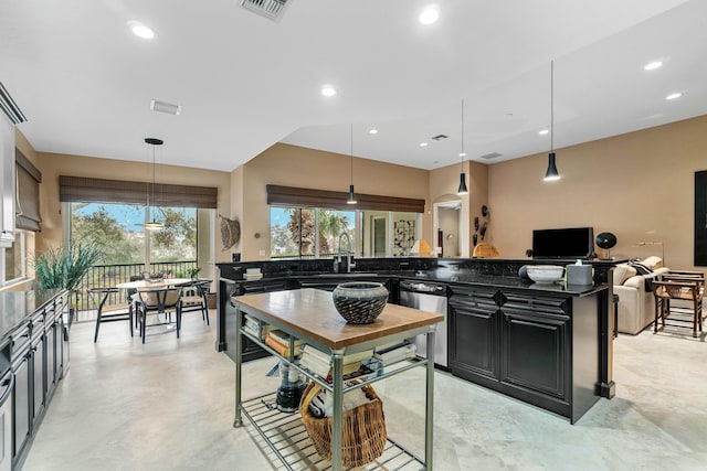 kitchen featuring decorative light fixtures, sink, dishwasher, and dark stone countertops