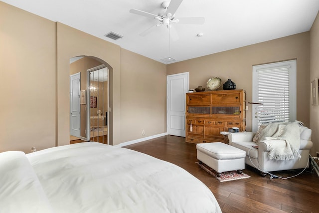 bedroom featuring arched walkways, dark wood finished floors, visible vents, ceiling fan, and baseboards