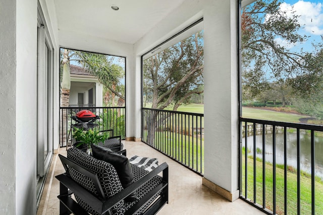 sunroom / solarium featuring a water view