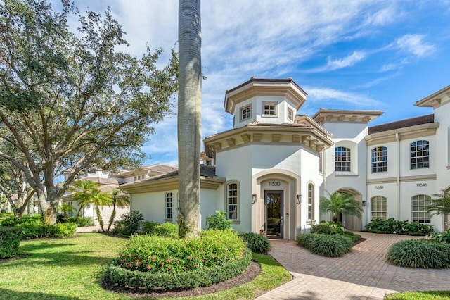 view of front facade featuring stucco siding and a front yard