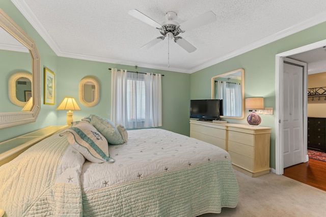 bedroom with a textured ceiling, crown molding, and carpet