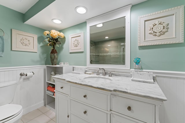 bathroom with tile patterned floors, toilet, vanity, and a tile shower