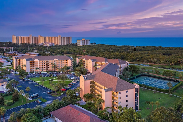 aerial view at dusk featuring a water view