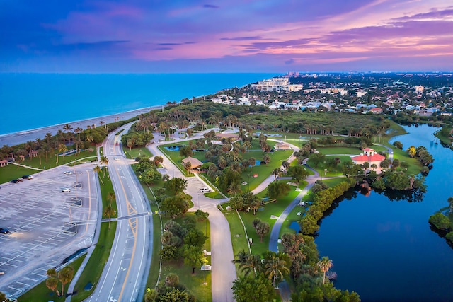 aerial view at dusk featuring a water view