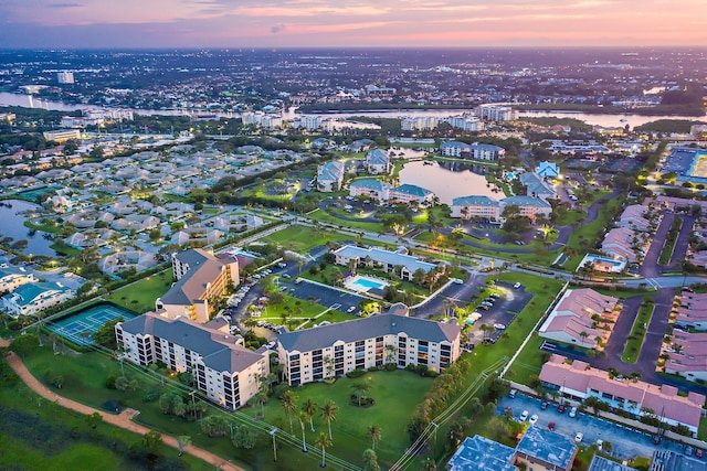 aerial view at dusk featuring a water view