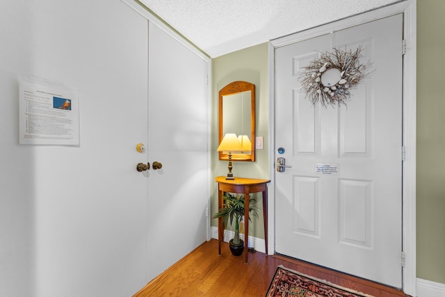 entryway with light hardwood / wood-style flooring and a textured ceiling