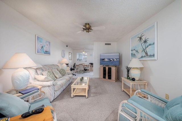 carpeted living room with ceiling fan and a textured ceiling