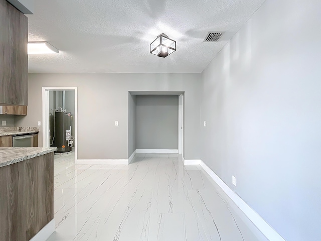 interior space with water heater and a textured ceiling