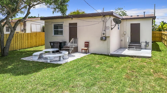 back of property with a yard and a patio