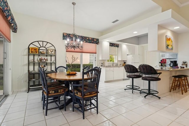 tiled dining space featuring an inviting chandelier