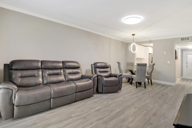 living room featuring ornamental molding and light wood-type flooring