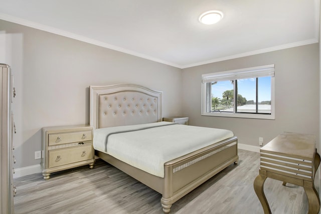 bedroom with crown molding and light wood-type flooring