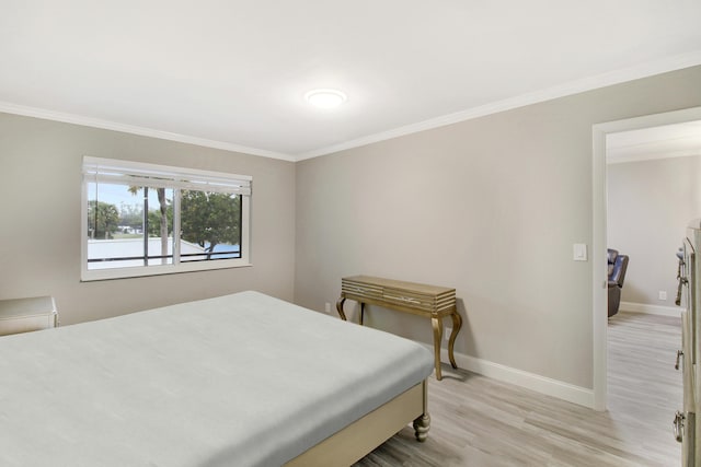 bedroom featuring ornamental molding and light hardwood / wood-style flooring