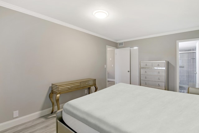 bedroom featuring connected bathroom, crown molding, and light hardwood / wood-style floors