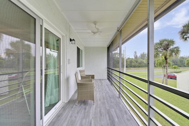 unfurnished sunroom with ceiling fan