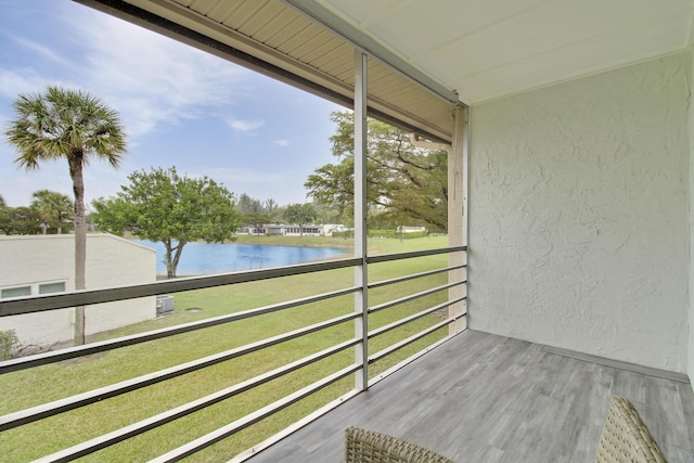 unfurnished sunroom featuring a water view