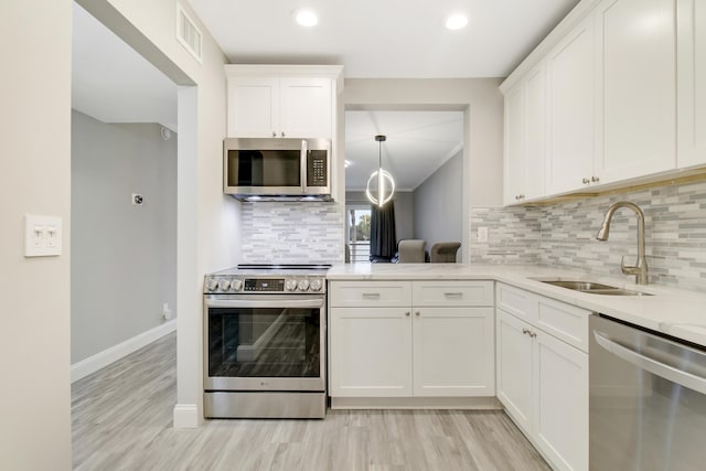 kitchen with white cabinetry, sink, decorative backsplash, and stainless steel appliances